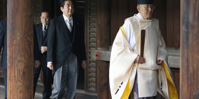 December 26, 2013: Japanese Prime Minister Shinzo Abe, second from right, follows a Shinto priest to pay respect for the war dead at Yasukuni Shrine in Tokyo. The visit to the shrine, which honors 2.5 million war dead including convicted class A war criminals, appears to be a departure from Abe’s “pragmatic” approach to foreign policy, in which he tried to avoid alienating neighboring countries. (AP)