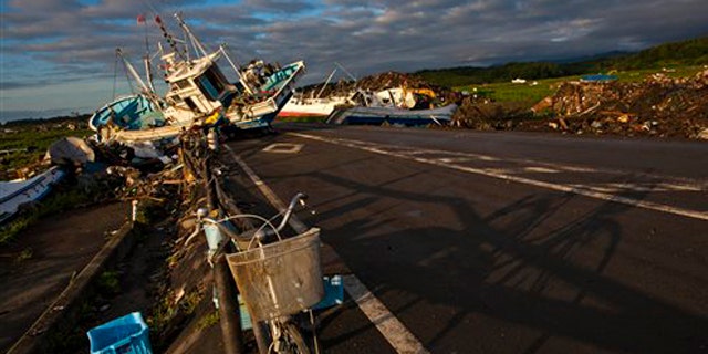July 24, 2011: In this file photo an abandoned bicycle rests on a road partially blocked by ships that washed ashore in the town of Namie, inside the 12-mile exclusion zone around the Fukushima Dai-ichi nuclear plant, in northeastern Japan.