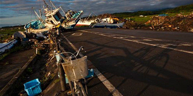 July 24, 2011: In this file photo an abandoned bicycle rests on a road partially blocked by ships that washed ashore in the town of Namie, inside the 12-mile exclusion zone around the Fukushima Dai-ichi nuclear plant, in northeastern Japan.
