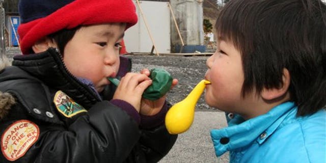 March 21, 2011: Children play with balloons at a shelter in the March 11 earthquake and tsunami-destroyed town of Minamisanriku, northern Japan.