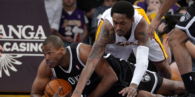 Brooklyn Nets center Jason Collins, left, battles for a loose ball with Los Angeles Lakers guard MarShon Brooks during the first half of an NBA basketball game, Sunday, Feb. 23, 2014, in Los Angeles. (AP Photo/Mark J. Terrill)