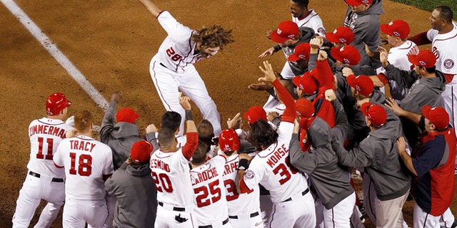 Washington Nationals' Jayson Werth leaps onto home plate after hitting a walk-off home run in the ninth inning against the St. Louis Cardinals in Game 4 of the National League baseball division series, Thursday, Oct. 11, 2012, in Washington.