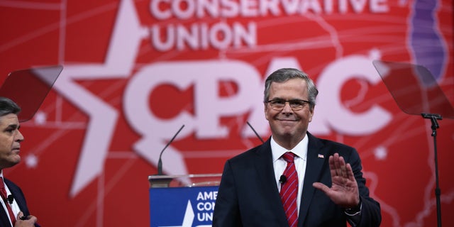 NATIONAL HARBOR, MD - FEBRUARY 27: Former Florida governor Jeb Bush (R) waves to the crowd as Sean Hannity (L) of Fox News looks on at the 42nd annual Conservative Political Action Conference (CPAC) February 27, 2015 in National Harbor, Maryland. Conservative activists attended the annual political conference to discuss their agenda. (Photo by Alex Wong/Getty Images)