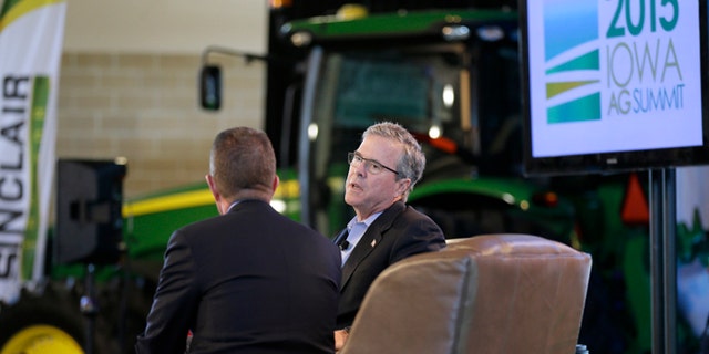 In this March 7, 2015, photo, former Florida Gov. Jeb Bush is interviewed by host Bruce Rastetter, left, during the Iowa Agriculture Summit in Des Moines, Iowa. After a flurry of fundraising, formal speeches about economics and global affairs Bush got down to business this weekend appearing at the Pizza Ranch in Cedar Rapids, Iowa, after a stop at the Agricultural Summit. (AP Photo/Charlie Neibergall)