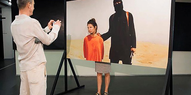The ISIS artwork on show at the festival An art installation where visitors are encouraged to have a photo taken next to an Islamic State terrorist waiting to behead them has been blasted by politicians