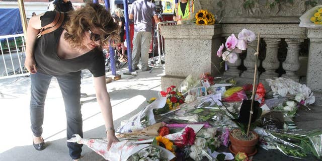 September 5, 2014. Paula Reardon places flowers at a sidewalk memorial for comedian Joan Rivers at the doorstep of her apartment building.