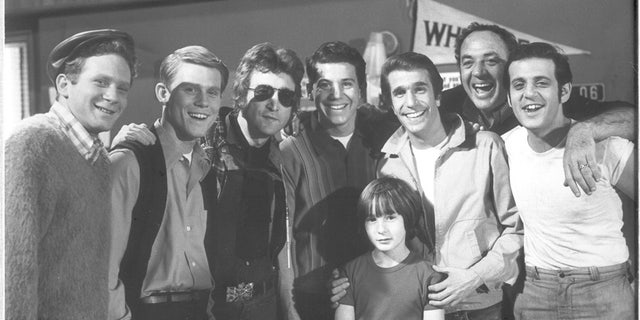 Anson Williams (center) poses with John Lennon and the rest of his "Happy Days" cast.