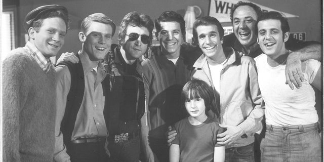 Anson Williams (center) poses with John Lennon and the rest of his "Happy Days" cast.