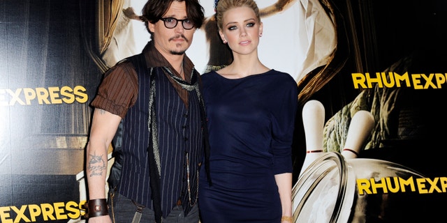 Johnny Depp and Amber Heard pose for photographers as they arrive for the premiere of the film "The Rum Diary" in Paris November 8, 2011