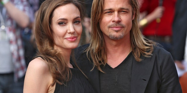Angelina Jolie poses with Brad Pitt at her first public appearance after announcing she underwent a double mastectomy in February 2013. Jolie tested positive for the BRCA gene.