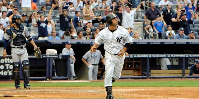 New York Yankees' Jorge Posdada, center, watches his grand slam during the fifth inning of a baseball game against the Tampa Bay Rays, Saturday, Aug. 13, 2011, at Yankee Stadium in New York. (AP Photo/Bill Kostroun)