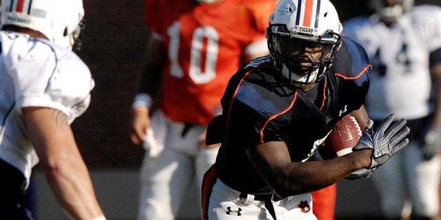 Aug. 6, 2012: Auburn running back Jovon Robinson is tackled by defender Jake Holland during NCAA college football practice on in Auburn, Ala.