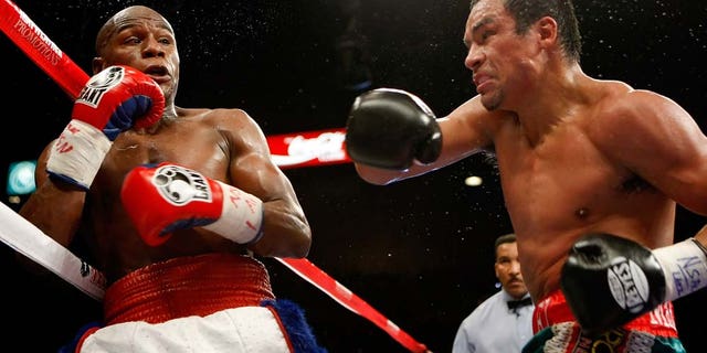 LAS VEGAS - SEPTEMBER 19: Floyd Mayweather Jr. (L) and Juan Manuel Marquez exchange blows in the fourth round of their fight at the MGM Grand Garden Arena September 19, 2009 in Las Vegas, Nevada. Mayweather won by unanimous decision. (Photo by Ethan Miller/Getty Images)