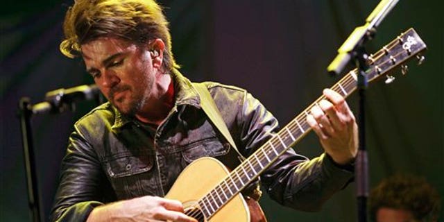 FILE - In this April 18, 2013 file photo, Colombian singer Juanes performs in a concert as a part of his Unplugged tour in Panama City. Juanes will launch his album Loco de Amor, on March 11, 2014. The singer said that the album recorded in live studio sessions at a studio and produced by Steve Lillywhite, is his best work to date. (AP Photo/Arnulfo Franco, File)