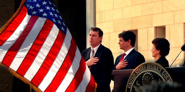 FILE- In this Nov. 14, 2005, file photo, U.S. Southern District Judge Andrew S. Hanen, left, joins with Filemon B. Vela, Jr. and Blanca Vela for the Pledge of Allegiance during the United States Courthouse naming ceremony in Brownsville, Texas. Hanen temporarily blocked President Barack Obamaâs executive action on immigration Monday, Feb. 16, 2015, giving a coalition of 26 states time to pursue a lawsuit that aims to permanently stop the orders. (AP Photo/The Brownsville Herald, Brad Doherty, File)