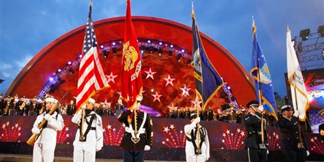 July 3: A military color guard stands ready for the playing of the National Anthem during the Boston Pops 4th of July concert rehearsal at the Hatch Shell on the Esplanade in Boston.
