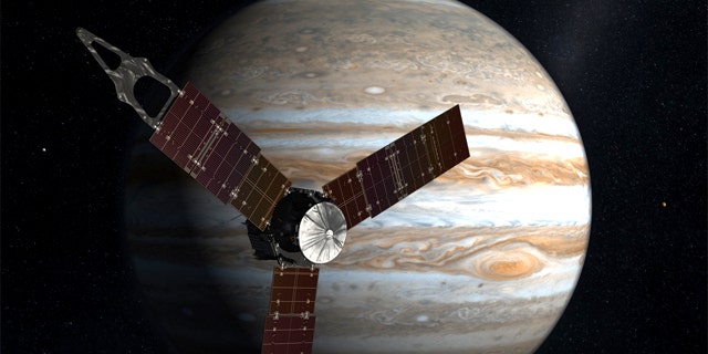The Juno spacecraft passes in front of Jupiter in this artist's depiction.