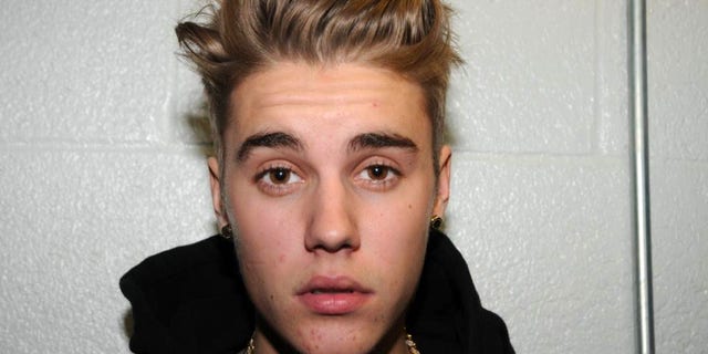 FILE - This Jan. 23, 2014 file photo made available by the Miami Beach Police Dept., shows Justin Bieber at the police station in Miami Beach, Fla. A new trial date could be set for Bieber in the Florida case charging him with driving under the influence, resisting arrest and possessing an invalid driver's license. A hearing was scheduled Tuesday, March 11, 2014, for the 20-year-old pop singer, who has pleaded not guilty. A previous trial date was postponed while attorneys for news organizations and Bieber wrestled with releasing police videos of him giving a drug test urine sample. (AP Photo/Miami Beach Police Dept., File)