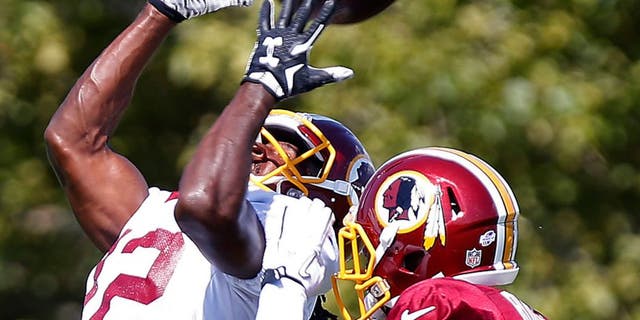 Aug 1, 2015; Richmond, VA, USA; Washington Redskins wide receiver Andre Roberts (12) catches the ball as defensive back Justin Rogers (25) defends during afternoon practice as part of day three of training camp at Bon Secours Washington Redskins Training Center. Mandatory Credit: Geoff Burke-USA TODAY Sports