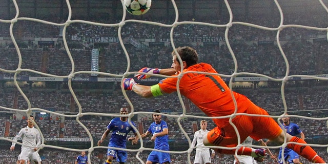 Juventus' Alvaro Morata, center rear, scores 1-1 passing Real Madrid's goalkeeper Iker Casillas during the Champions League second leg semifinal soccer match between Real Madrid and Juventus, at the Santiago Bernabeu stadium in Madrid, Wednesday, May 13, 2015. The match ended in a 1-1 draw, Juventus won on aggregate and will play Barcelona in the Champions League final on June 6, 2015 in Berlin. (AP Photo/Daniel Ochoa de Olza)