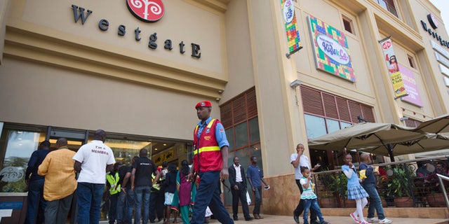 A security guard patrols outside the reopened Westgate Shopping Mall, nearly two years after a terrorist attack there left at least 67 people dead, in the capital Nairobi, Kenya Saturday, July 18, 2015. Hundreds of shoppers thronged through the reopened mall Saturday, following two years of repairs after security forces battled four gunmen from Somalia's al-Qaida-linked al-Shabab militant group there in September 2013. (AP Photo/Ben Curtis)