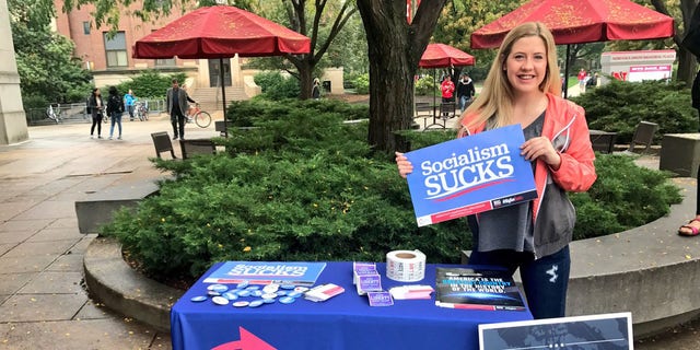 University of Nebraska student Kaitlyn Mullen standing at a table she set up to recruit members for the conservative group Turning Point USA.