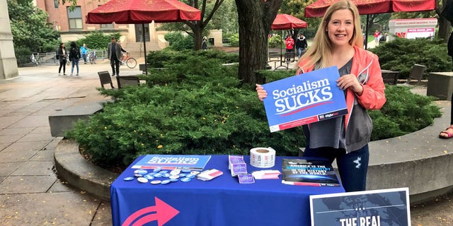 University of Nebraska student Kaitlyn Mullen standing at a table she set up to recruit members for the conservative group Turning Point USA.