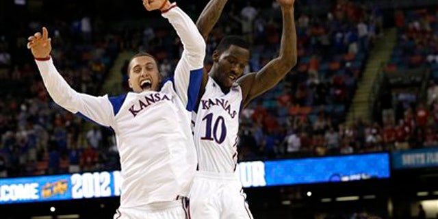 Kansas guard Tyshawn Taylor (10) celebrates with Kansas guard Christian Garrett at the end of an NCAA Final Four semifinal college basketball tournament game against Ohio State.