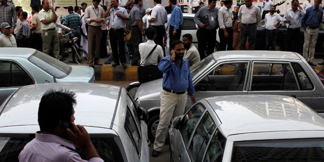April 16, 2013: Office workers stand outside of their buildings following an earthquake tremor in Karachi. An magnitude 7.8 earthquake struck Iran on Tuesday with tremors felt across Pakistan among other regions, media reported.
