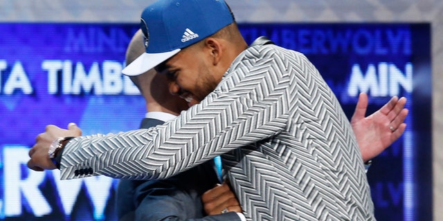 Karl-Anthony Towns, right, is greeted by NBA Commissioner Adam Silver after the Minnesota Timberwolves selected Towns, a Kentucky center, with the top pick in the NBA basketball draft, Thursday, June 25, 2015, in New York. (AP Photo/Kathy Willens)