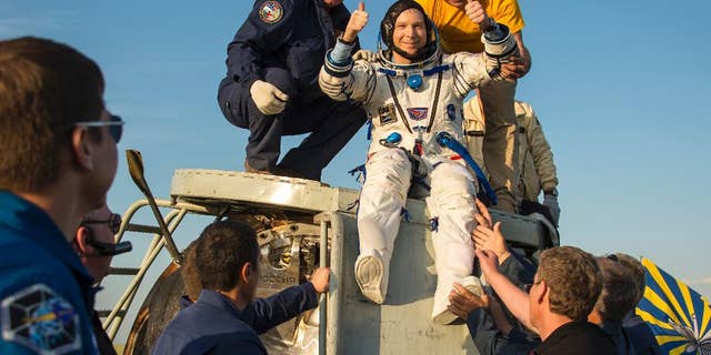 In this photo provided by NASA, United States astronaut Terry Virts is helped out of the Soyuz TMA-15M spacecraft just minutes after he and Russian cosmonaut Anton Shkaplerov, center, and Italian astronaut Samantha Cristoforetti landed in a remote area near the town of Zhezkazgan, Kazakhstan, Thursday, June 11, 2015.