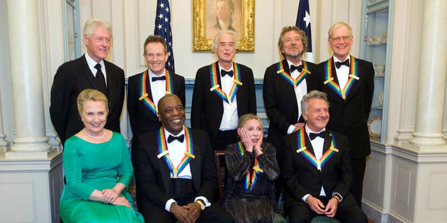 2012 Kennedy Center Honoree Natalia Makarova, front row, second right, reacts to all the photos being taken during a group photo after the State Department Dinner for the Kennedy Center Honors gala Saturday, Dec. 1, 2012 at the State Department in Washington. From left are former President Bill Clinton, Secretary of State Hillary Rodham Clinton, John Paul Johns, Buddy Guy, Jimmy Page, Makarova, Robert Plant, Dustin Hoffman and David Letterman. (AP Photo/Kevin Wolf)