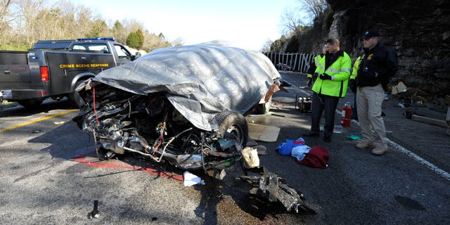 In this Friday, March 26, 2010 picture, Kentucky State Police investigate the scene of an accident involving a tractor-trailer and a van on Interstate 65, four miles north of Horse Cave, Ky. National Transportation Safety Board investigators on Tuesday, Sept. 13, 2011 said that 45-year-old truck driver Kenneth Laymon of Jasper, Ala., had just made an outgoing call that lasted one second before his truck struck a van carrying a Mennonite family and friends to a wedding in Iowa.