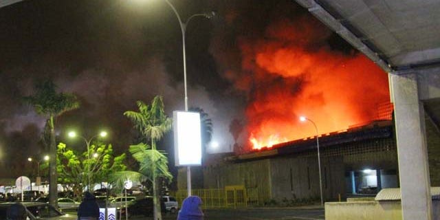 August 7, 2013: People watch a large blaze raging at the Jomo Kenyatta International Airport in Nairobi, Kenya early Tuesday. (AP Photo/Kyodo News)
