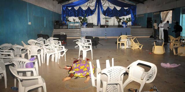 The body  of the a worshipper lies on the floor inside Kenyan Joyland church in Likoni,  near Mombasa, Kenya Sunday, March 23, 2014. Kenyan officials said  three people died after gunmen opened fire in a church just outside the coastal city of Mombasa. The Interior Ministry said Sunday that three gunmen opened fire inside the Joyland Church killing a small number of  people. At least 10  were wounded.  (AP Photo)