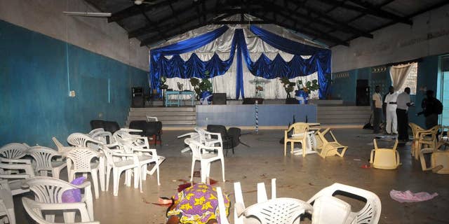 The body of the a worshipper lies on the floor inside Kenyan Joyland church in Likoni, near Mombasa, Kenya Sunday, March 23, 2014. Kenyan officials said three people died after gunmen opened fire in a church just outside the coastal city of Mombasa. The Interior Ministry said Sunday that three gunmen opened fire inside the Joyland Church killing a small number of people. At least 10 were wounded. (AP Photo)