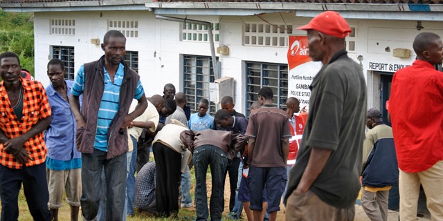 July 6, 2014: People watch the site where gunmen attacked outside the Gamba police station in Gamba, Kenya. (AP Photo)