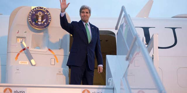 FILE - In this Oct. 15, 2014 file-pool photo Secretary of State John Kerry waves as he boards his plane at Orly Airport, south of Paris, France, en route to Vienna, Austria. The US may be the mightiest military and economic power in the world but when it comes to shuttling its top diplomat around the globe, it’s beginning to look like a poor orphan. For the fourth time this year _ and the second time in three months, Kerry was forced to fly home commercially when his aging Air Force Boeing 757, known in military parlance as a C-32, was grounded on Thursday with a mechanical problem in Vienna. (AP Photo/Carolyn Kaster, File-Pool)