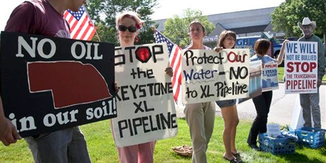 July 26: Protestors opposed to the Keystone XL pipeline hold signs outside the office of Rep. Lee Terry, R-Neb., in Omaha, Neb.