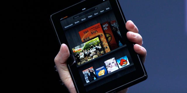 Amazon CEO Jeff Bezos holds up the new Kindle Fire at a news conference during the launch of Amazon's new tablets in New York, September 28, 2011. REUTERS/Shannon Stapleton (UNITED STATES - Tags: BUSINESS SCIENCE TECHNOLOGY) - RTR2RYAH