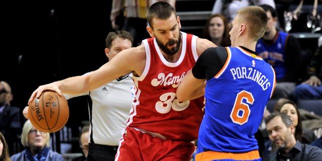 Memphis Grizzlies center Marc Gasol (33) controls the ball against New York Knicks forward Kristaps Porzingis (6) in the first half of an NBA basketball game Saturday, Jan. 16, 2016, in Memphis, Tenn. (AP Photo/Brandon Dill)