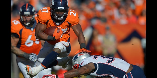 Denver Broncos running back Knowshon Moreno (27) leaps over New England Patriots strong safety Duron Harmon (30) during the first half of the AFC Championship NFL playoff football game in Denver, Sunday, Jan. 19, 2014. (AP Photo/Jack Dempsey)