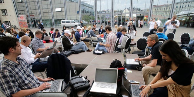 People use their laptops during "Working everywhere" event in Riga May 31, 2013. More than 150 activists with laptops and wi-fi access attended event to demonstrate the benefits of flexible working style and possibly set a new Guinness world record for "Most people who work in a specific place outside the office". REUTERS/Ints Kalnins (LATVIA - Tags: SOCIETY) - RTX107GW