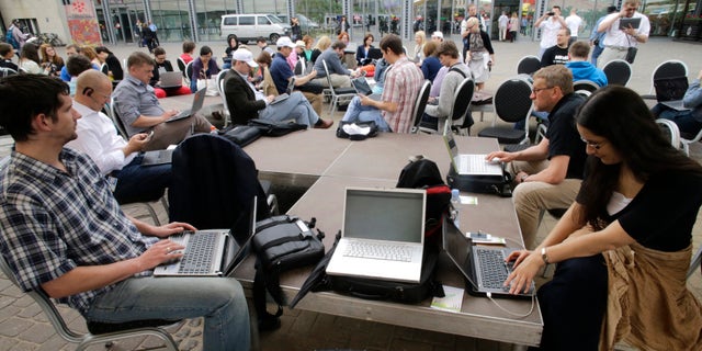 People use their laptops during "Working everywhere" event in Riga May 31, 2013. More than 150 activists with laptops and wi-fi access attended event to demonstrate the benefits of flexible working style and possibly set a new Guinness world record for "Most people who work in a specific place outside the office". REUTERS/Ints Kalnins (LATVIA - Tags: SOCIETY) - RTX107GW