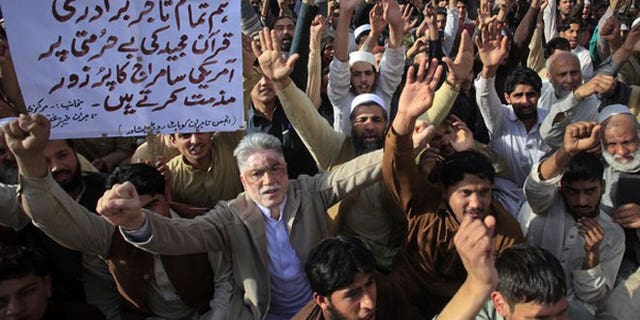 March 6, 2012: Traders hold placards as they shout anti-U.S. slogans during a demonstration in Peshawar. About 200 protesters gathered to condemn the February 21 burning of copies of the Koran at NATO's main base in Afghanistan.