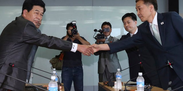 Aug. 14, 2013: Kim Kiwoong, right, the head of South Korea's working-level delegation, shakes hands with his North Korean counterpart Park Chol Su, left, before their meeting at Kaesong Industrial District Management Committee in Kaesong, North Korea.