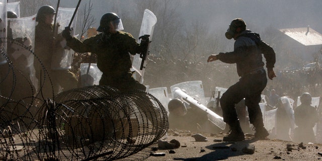 Nov. 28: Kosovo Serbs clash with German army soldiers serving under the auspices of the NATO peacekeeping mission in Kosovo, as the NATO troops work to remove a roadblock near the village of Jagnjenica, Kosovo.