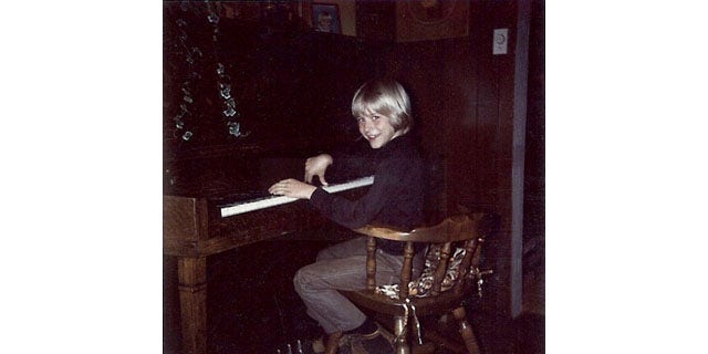 In this undated photo provided by Kim Cobain, a young Kurt Cobain plays piano in his childhood home in Aberdeen, Wash.