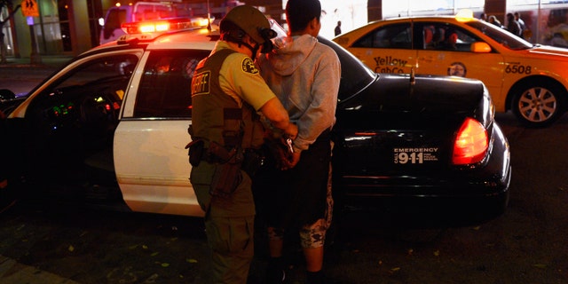 LOS ANGELES, CA - JUNE 11: A Los Angeles County Sheriff's Deputy releases a man after detaining him during disturbances after the Los Angeles Kings defeated the New Jersey Devils to win the 2012 Stanley Cup Final June 11, 2012 in Los Angeles, California. The win is the Kings first NHL championship in franchise history. (Photo by Kevork Djansezian/Getty Images)