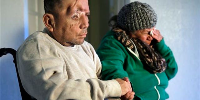 Walter DeLeon, left, discusses the details of his shooting last June as his mother Elisa cries on Wednesday, Dec. 2, 2015, in Covina, Calif. DeLeon, who lost a quarter of his skull after being shot by a Los Angeles police officer, has filed notice that he plans to sue the city and police department. (AP Photo/Chris Carlson)